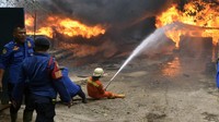 Petugas pemadam kebakaran berusaha memadamkan api yang membakar gudang penampungan BBM jenis solar di Teluk Betung Timur, Bandar Lampung, Lampung, Senin (4/11/2024). 
