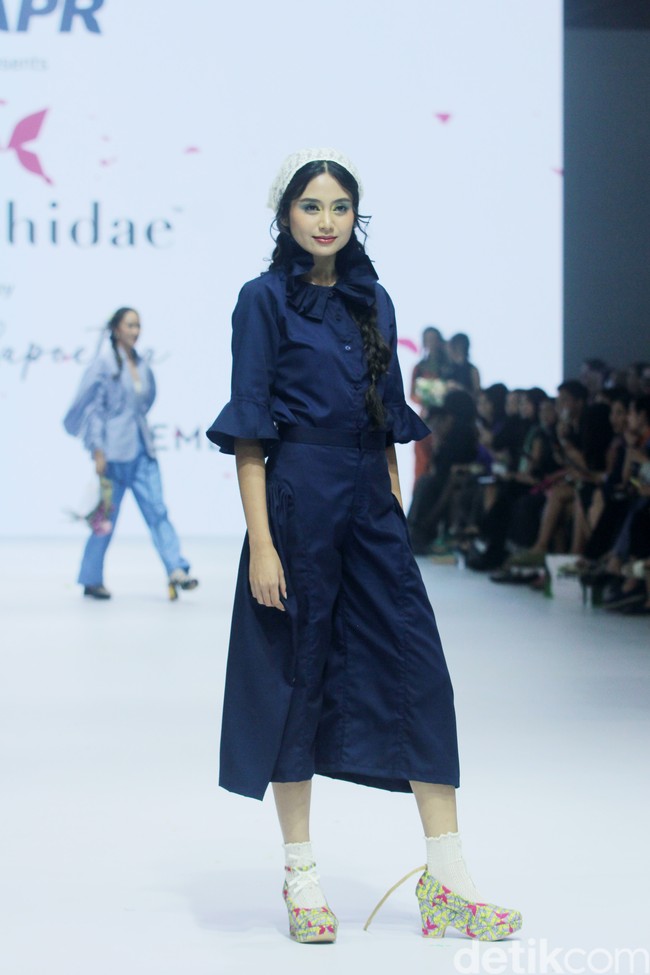 Fashion show koleksi Tities Saputra di Jakarta Fashion Week 2025, City Hall, Pondok Indah mall 3, Jakarta Selatan. Tities memamerkan rancangannya untuk lini Morphidae dan Emba Ladies. Dalam Morphidae bertema Calma, Tities menampilkan baju-baju feminin warna-warni yang bisa dipakai sehari-hari. Sedangkan untuk koleksi EMBA Ladies, Tities menampilkan revolusi denim yang lebih chic. Foto: Mohammad Abduh/detikcom.