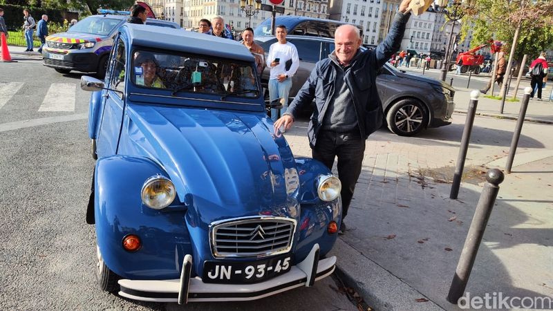 Mobil klasik Citroen 2CV seliweran di jalanan Paris, Prancis.
