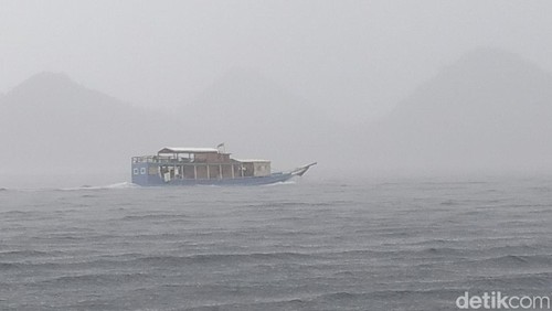 Sebuah Kapal pinisi berlayar dalam kondisi hujan lebat di perairan Labuan Bajo, Manggarai Barat, Nusa Tenggara Timur (NTT).