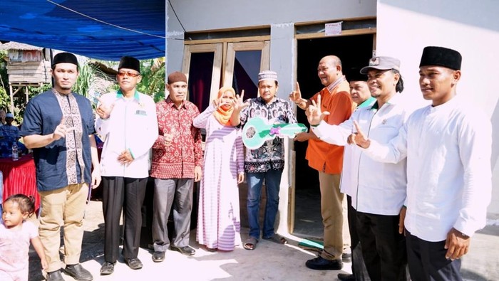 Syah Afandin saat menjadi Plt Bupati Langkat menyerahkan kunci rumah secara simbolis setelah selesai dibedah