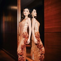 Dress rancangan desainer Yogie Pratama itu tampak mewah dipenuhi manik-manik berwarna oranye. Tak berlengan, bagian samping dress tampak terbuka hingga memperlihatkan beberapa tato di samping tubuh Amanda. Foto: Instagram/@snap.nuel