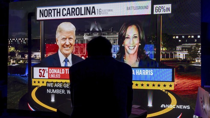 A supporter of Democratic presidential nominee Vice President Kamala Harris looks at U.S. presidential election results, during an election night party organized by Americans in Geneva, Switzerland, Tuesday, Nov. 5, 2024. (Salvatore Di Nolfi/Keystone via AP)