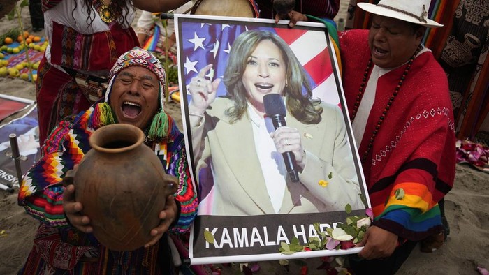 Shamans perform a good luck ritual holding photo a poster of Democratic presidential nominee Vice President Kamala Harris, at the beach in Lima, Peru, Tuesday, Nov. 5, 2024. (AP Photo/Martin Mejia)