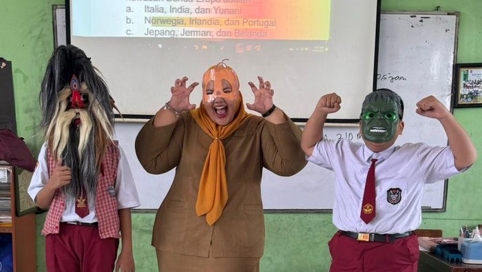 Guru kelas 6 SD Negeri Sememi 1 Surabaya, Intan Kusumaningrum SPd bersama siswanya memakai topeng saat ujian matematika.