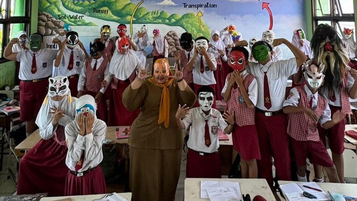 Guru kelas 6 SD Negeri Sememi 1 Surabaya, Intan Kusumaningrum SPd bersama siswanya memakai topeng saat ujian matematika.