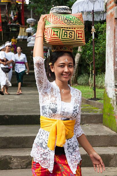 Ubud, Indonesia - March 2, 2016: Young woman with basket on the head during the celebration before Nyepi (Balinese Day of Silence).