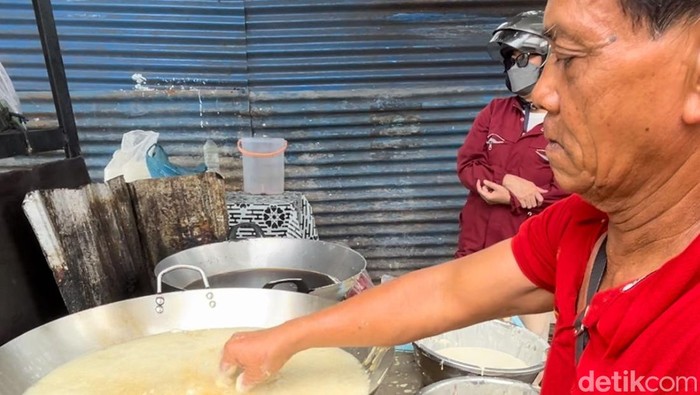 Pedagang gorengan berjualan sambil mencelupkan tangan ke minyak panas di Medan. (Kartika Sari/detikSumut)