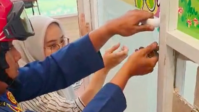 Petugas Damkar Jakut menyelamatkan siswa yang terkunci dalam ruang kelas di sebuah sekolah di Kelapa Gading. (dok Damkar Jakut)