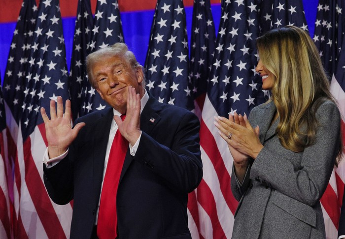 Republican presidential nominee and former U.S. President Donald Trump gestures while accompanied by his wife Melania at his rally, at the Palm Beach County Convention Center in West Palm Beach, Florida, U.S., November 6, 2024. REUTERS/Brian Snyder