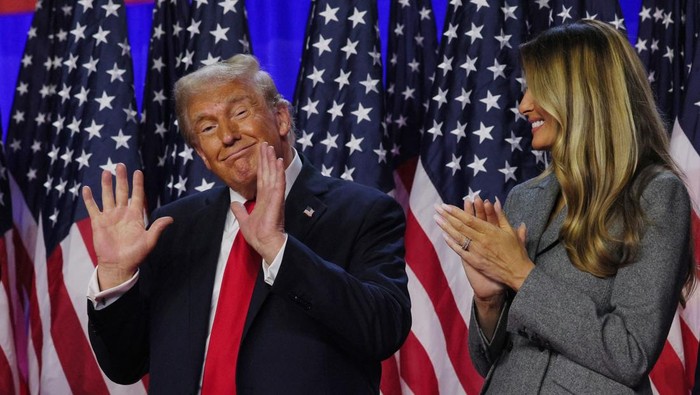 Republican presidential nominee and former U.S. President Donald Trump gestures while accompanied by his wife Melania at his rally, at the Palm Beach County Convention Center in West Palm Beach, Florida, U.S., November 6, 2024. REUTERS/Brian Snyder