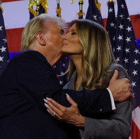 Salah satu momen yang paling disorot adalah ketika Donald Trump mencoba memeluk dan mencium Melania di atas panggung. Darren mencatat bahwa Melania tampak enggan melakukannya hingga terlihat canggung.  Foto: REUTERS/Brian Snyder