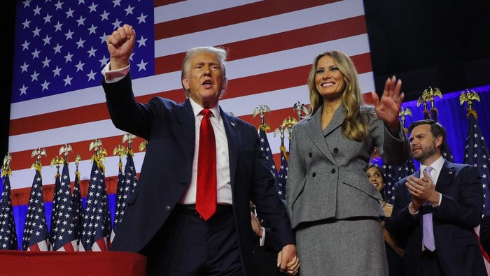 Republican presidential nominee and former U.S. President Donald Trump pumps his fist while accompanied by his wife Melania at his rally, at the Palm Beach County Convention Center in West Palm Beach, Florida, U.S., November 6, 2024. REUTERS/Brian Snyder