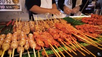 Selanjutnya, Tanboy Kun menghampiri kedai aneka sate, ia membeli beberapa tusuk sate berupa daging ayam, kulit ayam, dan sate hati ayam. Ia juga menikmati nasi ayam bumbu madu. Totalnya hanya 105 Baht (Rp 48 ribuan). Foto: YouTube Tanboy Kun
