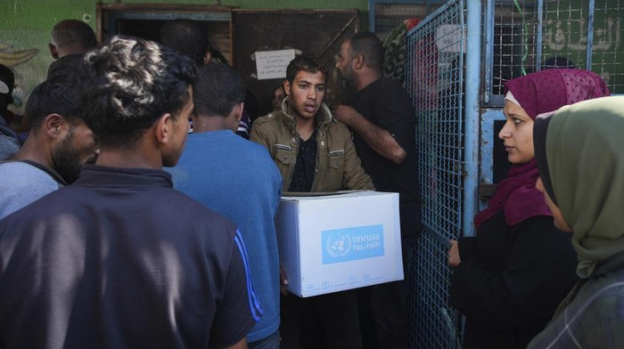 Palestinians receive aid distributed by UNRWA, the U.N. agency helping Palestinian refugees, in Nusairat refugee camp, Gaza, Tuesday, Nov. 5, 2024. (AP Photo/Abdel Kareem Hana)