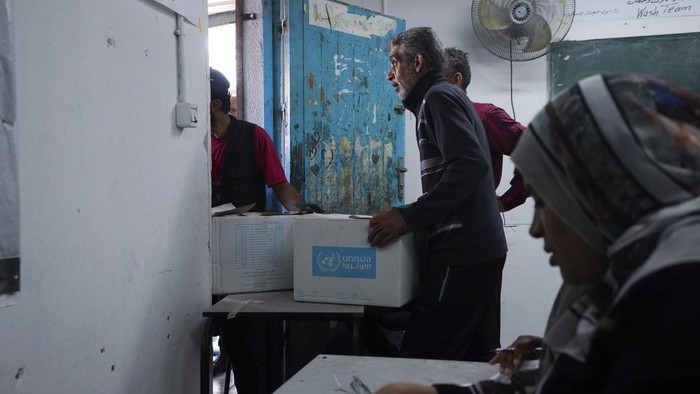 Palestinians receive aid distributed by UNRWA, the U.N. agency helping Palestinian refugees, in Nusairat refugee camp, Gaza, Tuesday, Nov. 5, 2024. (AP Photo/Abdel Kareem Hana)