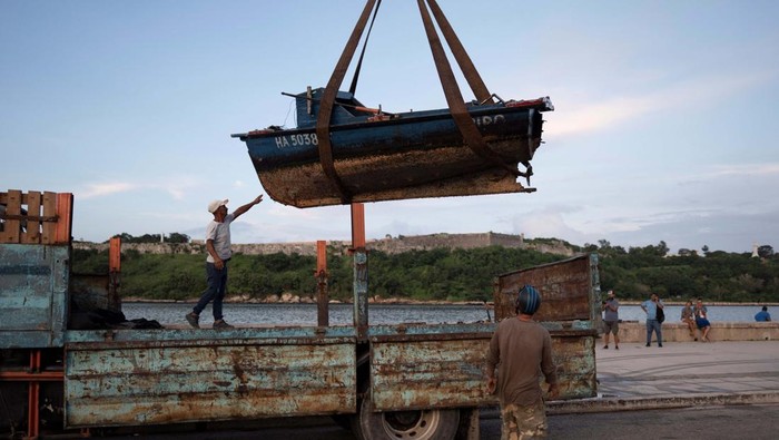 Warga Kuba Bersiap Hadapi Badai Tropis Rafael Men relocate furniture from a restaurant prior to the arrival of Tropical Storm Rafael in Havana, Cuba, November 5, 2024. REUTERS/Alexandre Meneghini
