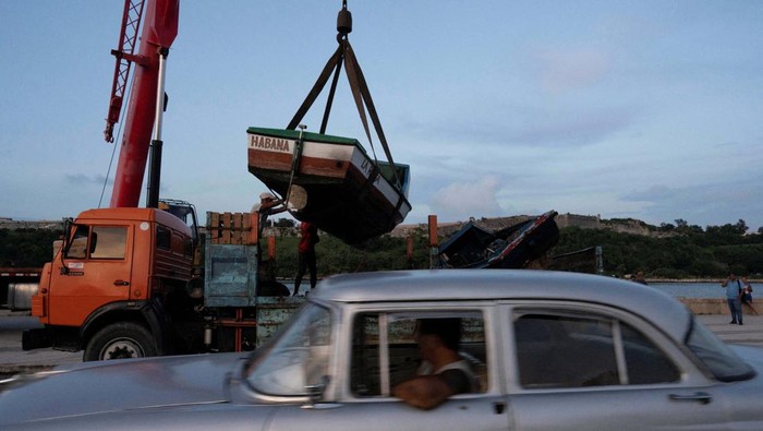 Men relocate furniture from a restaurant prior to the arrival of Tropical Storm Rafael in Havana, Cuba, November 5, 2024. REUTERS/Alexandre Meneghini
