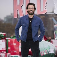 Pria 43 tahun ini memilih gaya casual dengan kaus dan celana hitam dipadu jaket suede warna biru. Kacamata dan kalung emas melengkapi busananya. Foto: Scott A Garfitt/Invision/AP