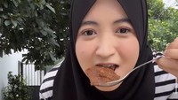 Kali ini, wanita kelahiran 1997 itu menunjukkan keseruannya saat menikmati rendang yang jadi lauk pelengkap dalam satu bungkus nasi Padangnya. Foto: Instagram @arafahrianti