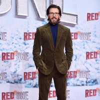 Bintang ‘The Avengers’ ini memilih preppy look dengan setelan jas cokelat dipadu turtle neck, tak lupa kacamata sebagai pelengkap gaya. Foto: Getty Images/Sebastian Reuter