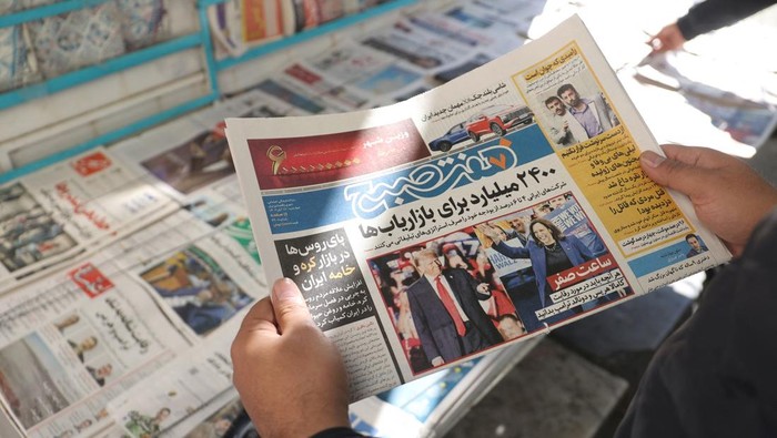 An Iranian man looks at a newspaper with a picture of Republican presidential nominee and former U.S. President Donald Trump and Democratic presidential nominee U.S. Vice President Kamala Harris, in Tehran, Iran November 6, 2024. Majid Asgaripour/WANA (West Asia News Agency) via REUTERS ATTENTION EDITORS - THIS PICTURE WAS PROVIDED BY A THIRD PARTY