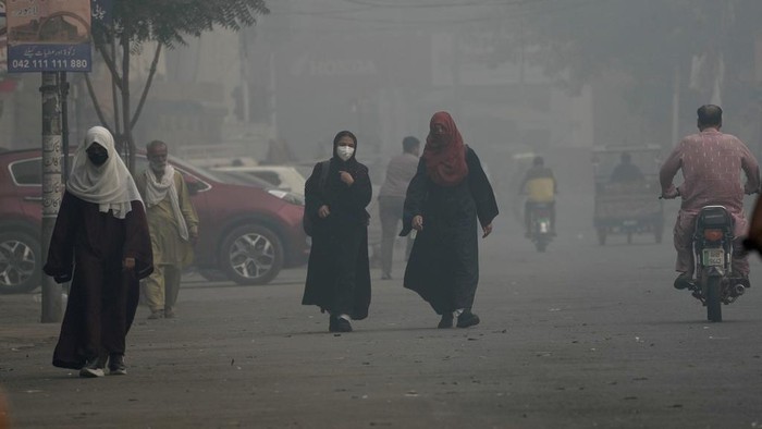 A cyclist, wearing mask, heads to his workplace as smog envelops the areas of Lahore, Pakistan, Wednesday, Nov. 6, 2024. (AP Photo/K.M. Chaudary)