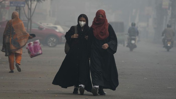A cyclist, wearing mask, heads to his workplace as smog envelops the areas of Lahore, Pakistan, Wednesday, Nov. 6, 2024. (AP Photo/K.M. Chaudary)