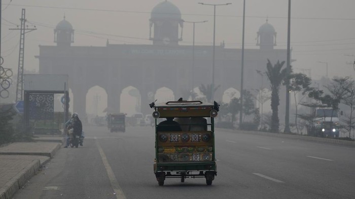 A cyclist, wearing mask, heads to his workplace as smog envelops the areas of Lahore, Pakistan, Wednesday, Nov. 6, 2024. (AP Photo/K.M. Chaudary)