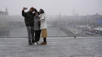 Warga beraktifitas di luar ruangan dengan jaket tebal.