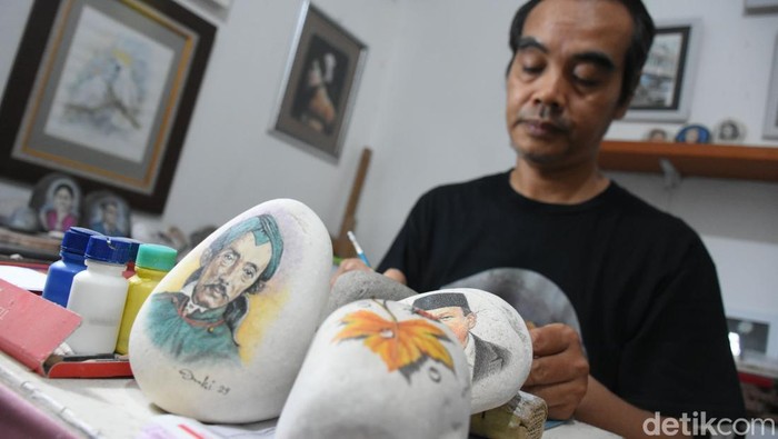 Seniman Bogor Sulap Batu Kali Jadi Karya Seni yang Unik Seorang pelukis menyelesaikan pembuatan lukisan pada batu kali di Kampung Warga Mulya, Kelurahan Sukasari, Kota Bogor, Jawa Barat, Kamis (7/10/2024).