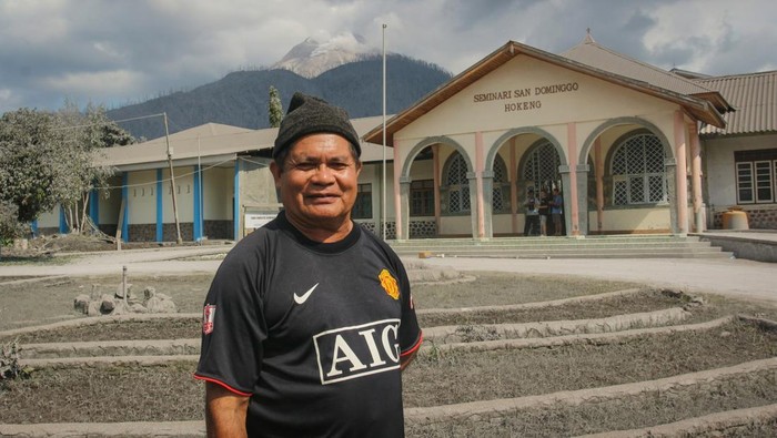 Rektor Seminari Menengah San Dominggo Pastor Martinus Kapitan Sogen berdiri dengan latar belakang sekolah yang dia pimpin di Hokeng Jaya, Wulanggitang, Kabupaten Flores Timur, Nusa Tenggara Timur, Rabu (6/11/2024). Meski seluruh warga desa telah mengungsi pascaerupsi Gunung Lewotobi Laki-laki, Romo Martinus memilih untuk tetap tinggal dan berjaga sebagai bentuk tanggung jawabnya sebagai kepala sekolah calon rohaniawan Katolik itu. ANTARA FOTO/Mega Tokan/app/foc.