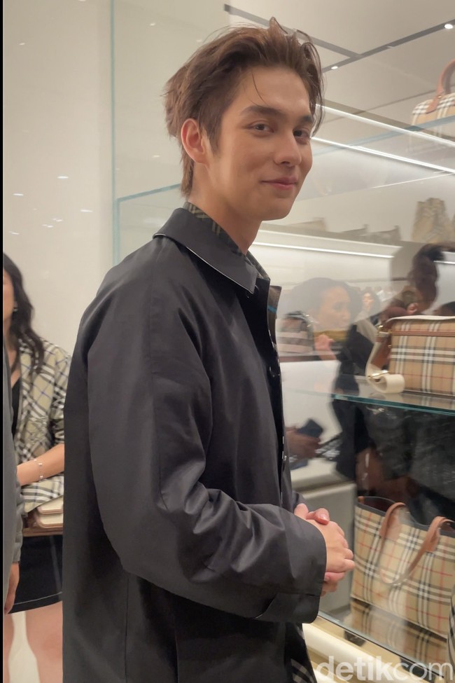 Begini gayanya saat memasuki butik di mana tengah digelar mini eksibisi yang menampilkan outerwear ikonik Burberry dari masa ke masa. Foto: Rahmi Anjani/Wolipop