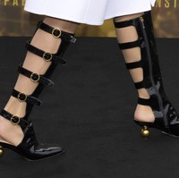 J.Lo terlihat memakai boots selutut berdetail gesper di sepanjang betis yang terkesan edgy. Foto: Scott A Garfitt/Invision/AP