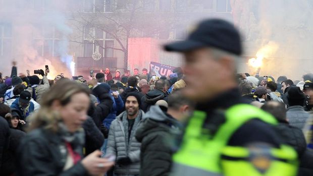 Pendukung Maccabi Tel Aviv asal Israel berdemonstrasi dan menyalakan suar saat seorang polisi berpatroli di area tersebut di Amsterdam, Belanda, 7 November 2024, dalam tangkapan layar yang diperoleh dari video media sosial. (Michel Van Bergen/via REUTERS)