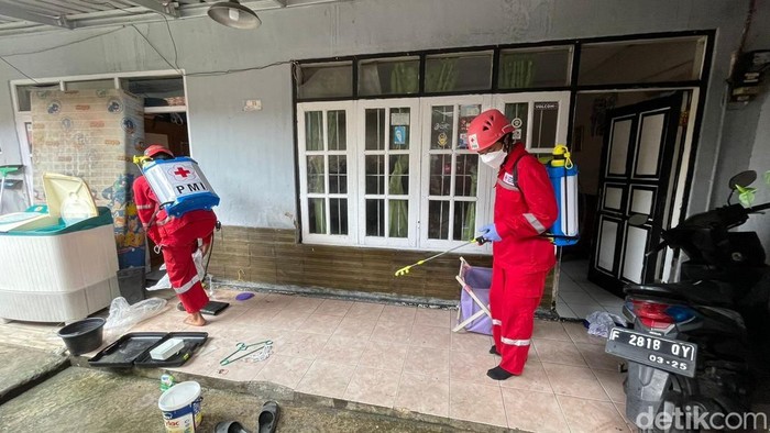 Petuga PMI menyemprotkan disinfektan di lokasi banjir di Sukabumi.