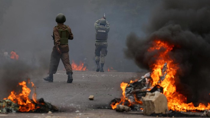 Protesters run from police during a 
