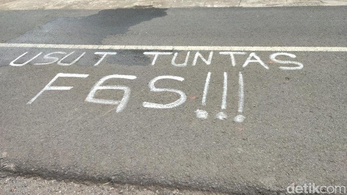 Tulisan mengenai Usut Tuntas FGS Global di jalan depan kantor desa yang diduga dibuat oleh korban.