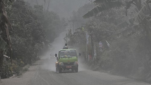 Pengendara mobil melintasi Jalan Trans Flores yang tertutup material pasir vulkanis dari erupsi Gunung Lewotobi Laki-laki di Desa Dulipali, Ilebura,  Kabupaten Flores Timur, Nusa Tenggara Timur, Sabtu (9/11/2024). Jalan Nasional yang menghubungkan Kabupaten Flores Timur dan Kabupaten Sikka tersebut masuk ke zona merah berbahaya dan terdampak parah dari material vulkanis sehingga aparat harus menutup jalan tersebut bila erupsi terjadi. ANTARA FOTO/Aditya Pradana Putra/foc.