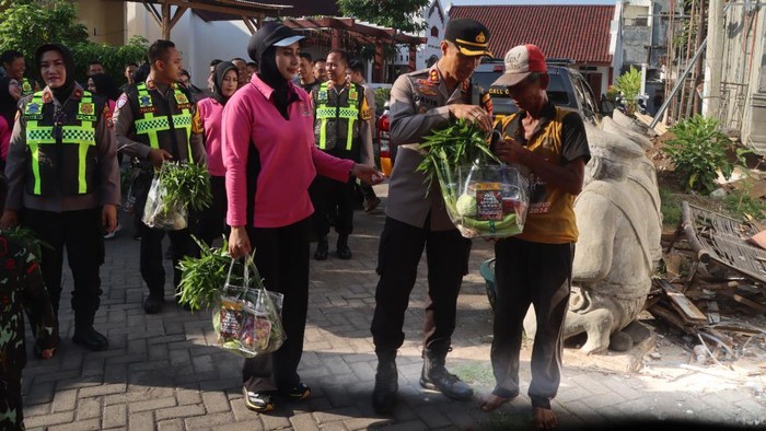 Kapolres Pasuruan AKBP Davis Busin Siswara membagikan sayuran kepada warga