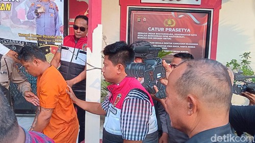 Agus (baju tahanan) ditahan di Polsek Densel setelah memburuh Asmara. (Aryo Mahendro/detikBali)