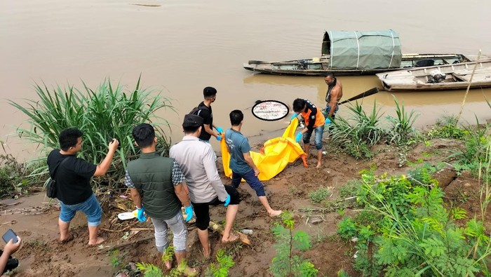 Polisi saat mengevakuasi mayat yang mengapung di Sungai Ogan, OKU