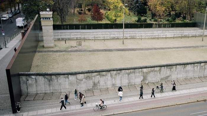 Visitors walk along remains of the Berlin Wall at the official Berlin Wall memorial site at Bernauer Strasse, in Berlin, Germany, Wednesday, Oct. 23, 2024. (AP Photo/Markus Schreiber)
