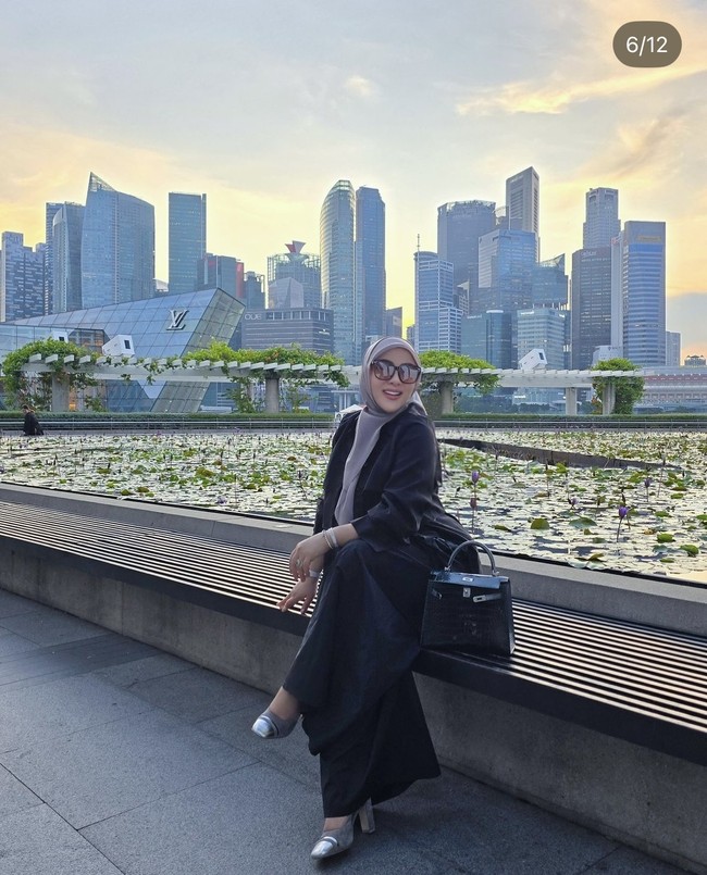 Wanita 44 tahun itu tampil mengenakan busana serba hitam. Ia kemudian memadukannya dengan hijab abu-abu dan sepatu berwarna silver. Melengkapi penampilannya Syahrini juga mengenakan kaca mata hitam. Foto: Instagram/@princessyahrini