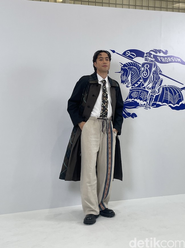 Vidi Aldiano adalah salah satu seleb Indonesia yang paling stylish dalam gelaran tersebut. Ia memadukan coat Burberry dan dasi dengan celana drawstring. Foto: Rahmi Anjani/Wolipop
