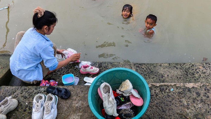 Warga mencuci sepatu di aliran kali Anyar, Cikeusal, Kabupaten Serang, Banten, Sabtu (9/11/2024). Berdasarkan data Badan Kependudukan dan Keluarga Berencana Nasional (BKKBN) Banten terdapat 77 ribu Kepala Keluarga (KK) di Banten tidak memiliki akses air bersih dan layak konsumsi yang menjadi salah satu faktor penyebab stunting bagi bayi.