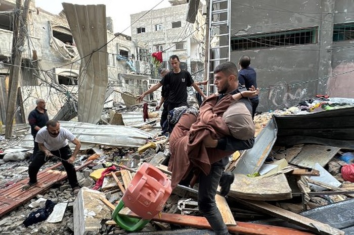 A man lies on a body in the back of a pickup truck, in the courtyard of the al-Shifa hospital in Gaza City after victims were transported there, following an Israeli strike that hit a school-turned-shelter in the Al-Shati refugee camp on November 7, 2024, amid the ongoing war between Israel and the Hamas militant group. (Photo by Omar AL-QATTAA / AFP)