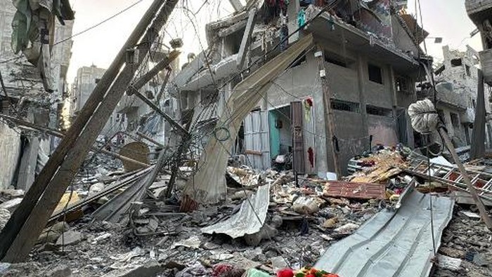 A man lies on a body in the back of a pickup truck, in the courtyard of the al-Shifa hospital in Gaza City after victims were transported there, following an Israeli strike that hit a school-turned-shelter in the Al-Shati refugee camp on November 7, 2024, amid the ongoing war between Israel and the Hamas militant group. (Photo by Omar AL-QATTAA / AFP)