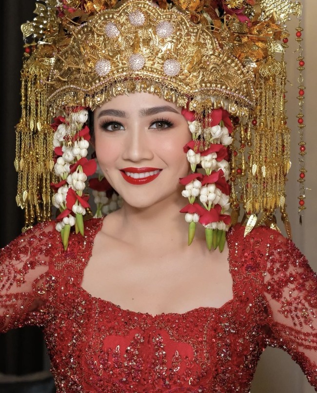 Baju Febby dipenuhi dengan detail payet dan bordir menambah kesan mewah elegan. Dia juga memakai aksesori kepala penuh ornamen emas dan bunga melati. Foto: dok. Instagram @morden.co, dok. Instagram @marlenehariman