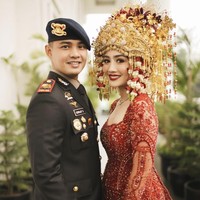 Dalam resepsi pernikahannya, Febby tampil memukau dengan baju pengantin Palembang berwarna merah menyala yang dirancang khusus oleh Studio Boh. Sedangkan suaminya Ajat memakai seragam lengkap dengan atribut polisi, yang dirancang oleh Wong Hang Tailor. Foto: dok. Instagram @morden.co, dok. Instagram @marlenehariman